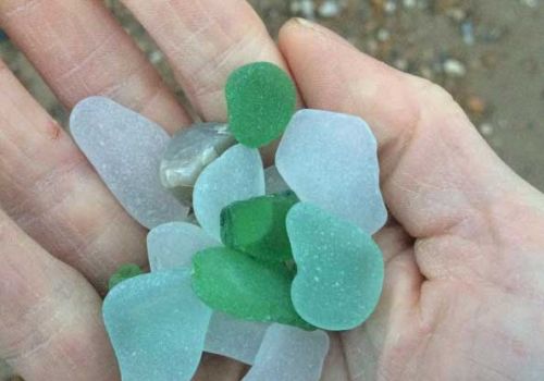 Images of beach glass pieces held in a hand at the beach
