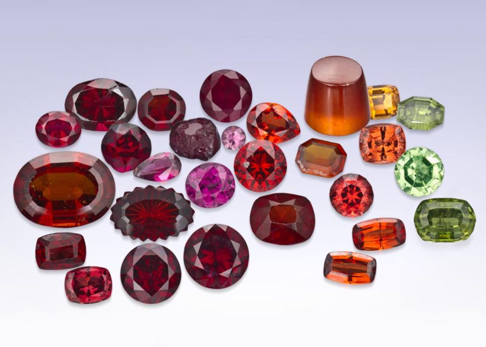 a collection of colorful red, pink, orange, yellow, green, and purple garnets