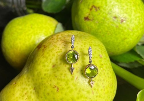set of green peridot gemstone earrings resting on a pear